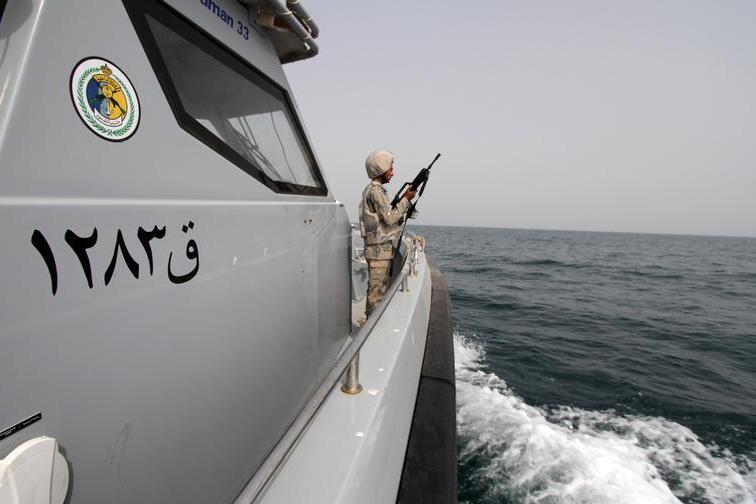 A Saudi border guard watches as he stands in a boat off the coast of the Red Sea on Saudi Arabias maritime border with Yemen, near Jizan