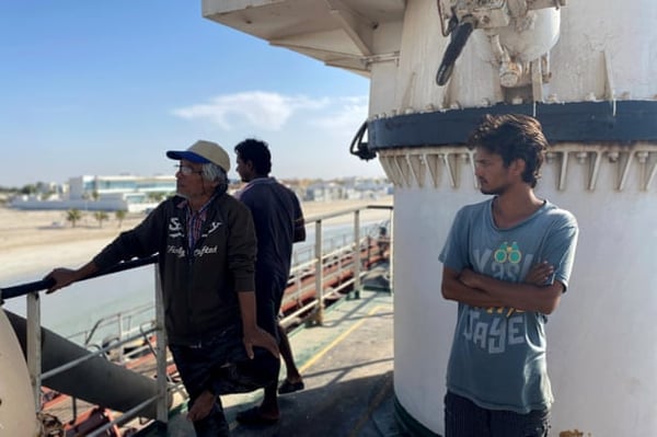 Nay Win, left, and other crew members of MT Iba look out to sea in Umm Al Quwain